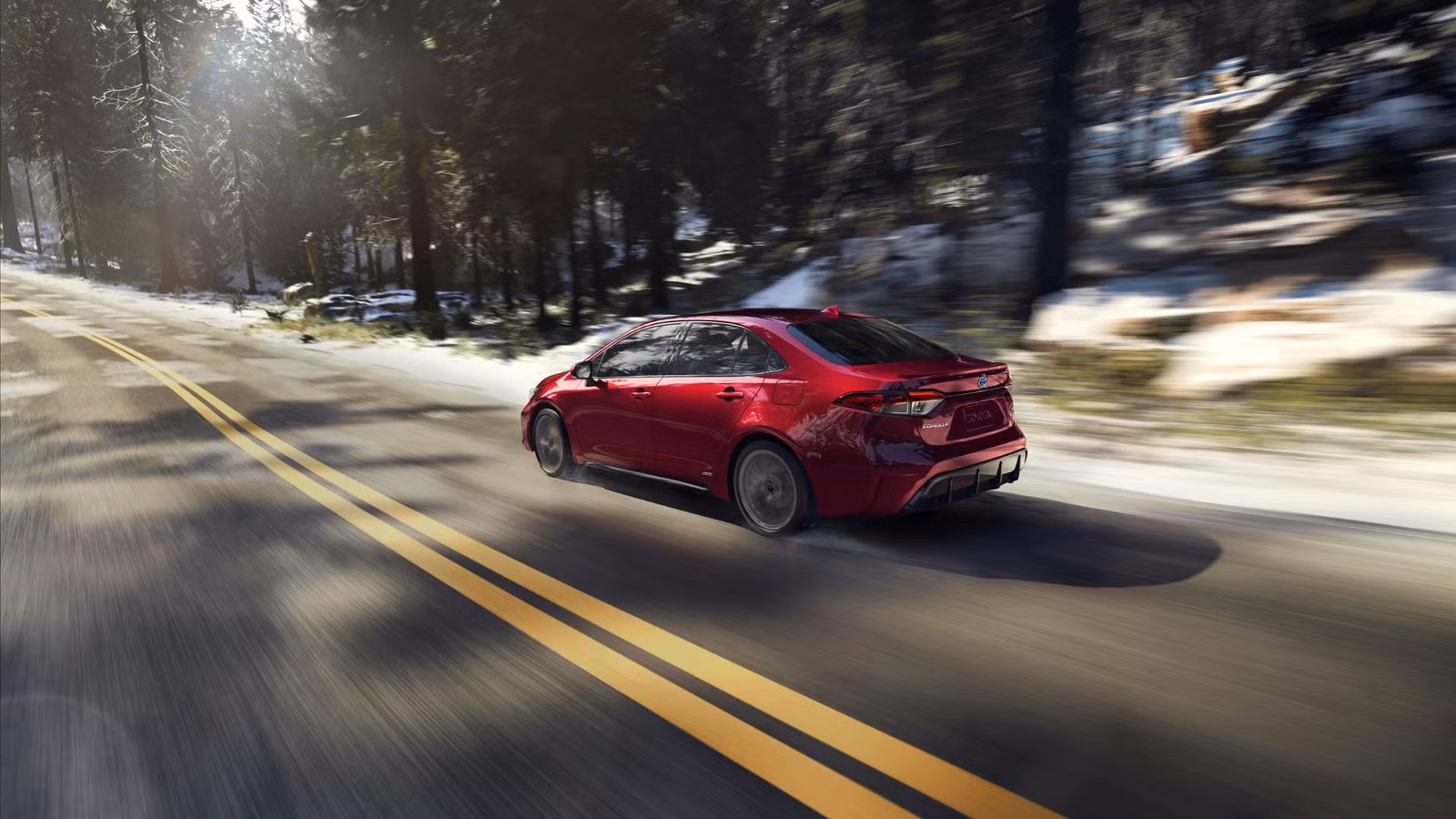 Toyota Corolla hybrid in motion on scenic road – dynamic red exterior